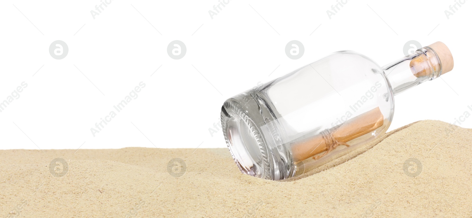 Photo of Rolled letter in corked glass bottle on sand against white background