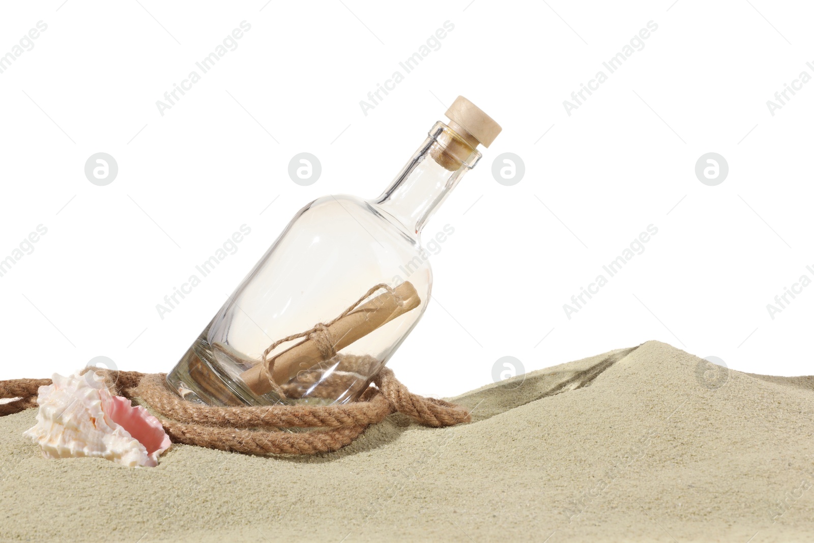 Photo of Rolled letter in corked glass bottle, rope and shell on sand against white background