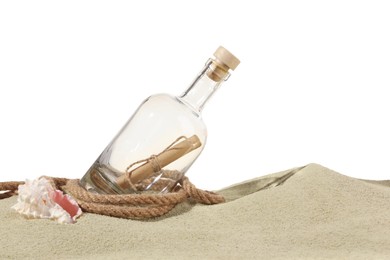 Photo of Rolled letter in corked glass bottle, rope and shell on sand against white background