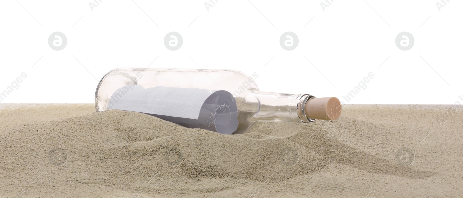 Photo of Rolled letter in corked glass bottle on sand against white background