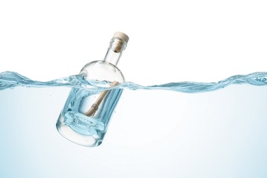 Photo of Corked glass bottle with rolled letter in water on white background