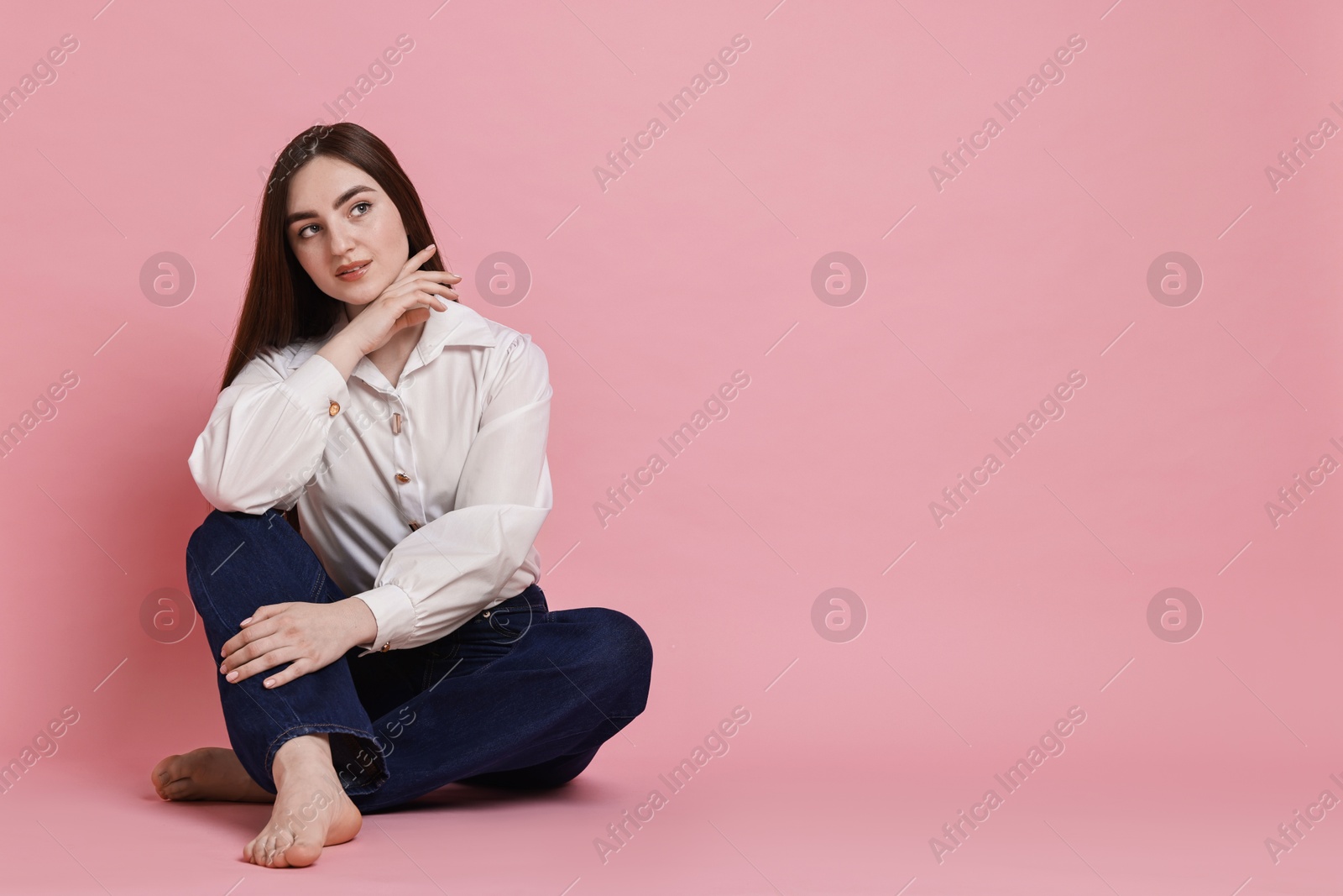 Photo of Woman in stylish jeans on pink background. Space for text