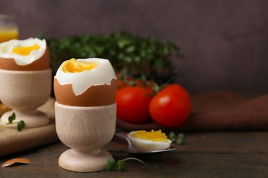 Photo of Soft boiled eggs, microgreens and tomatoes on wooden table, selective focus. Space for text