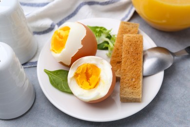 Photo of Soft boiled eggs with bread on grey table, closeup