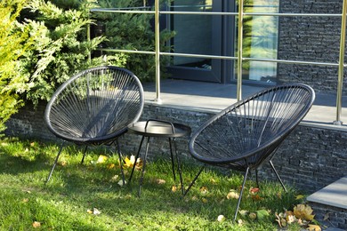 Stylish chairs and coffee table near building outdoors