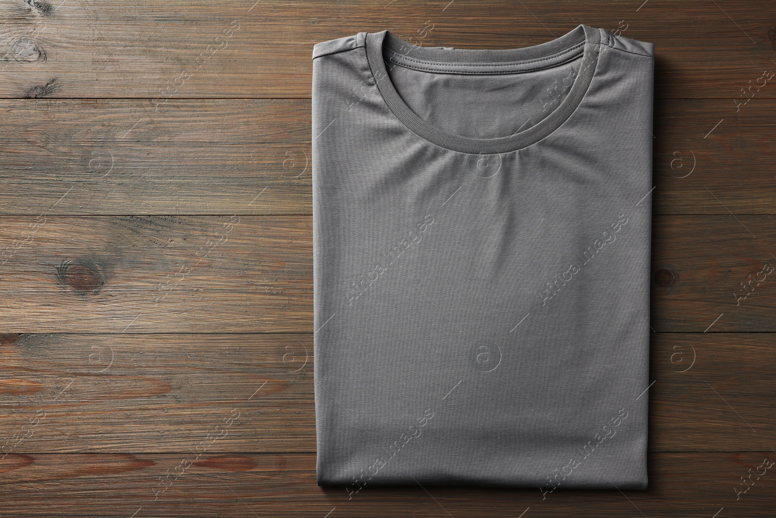 Photo of Blank grey t-shirt on wooden background, top view. Mockup for design