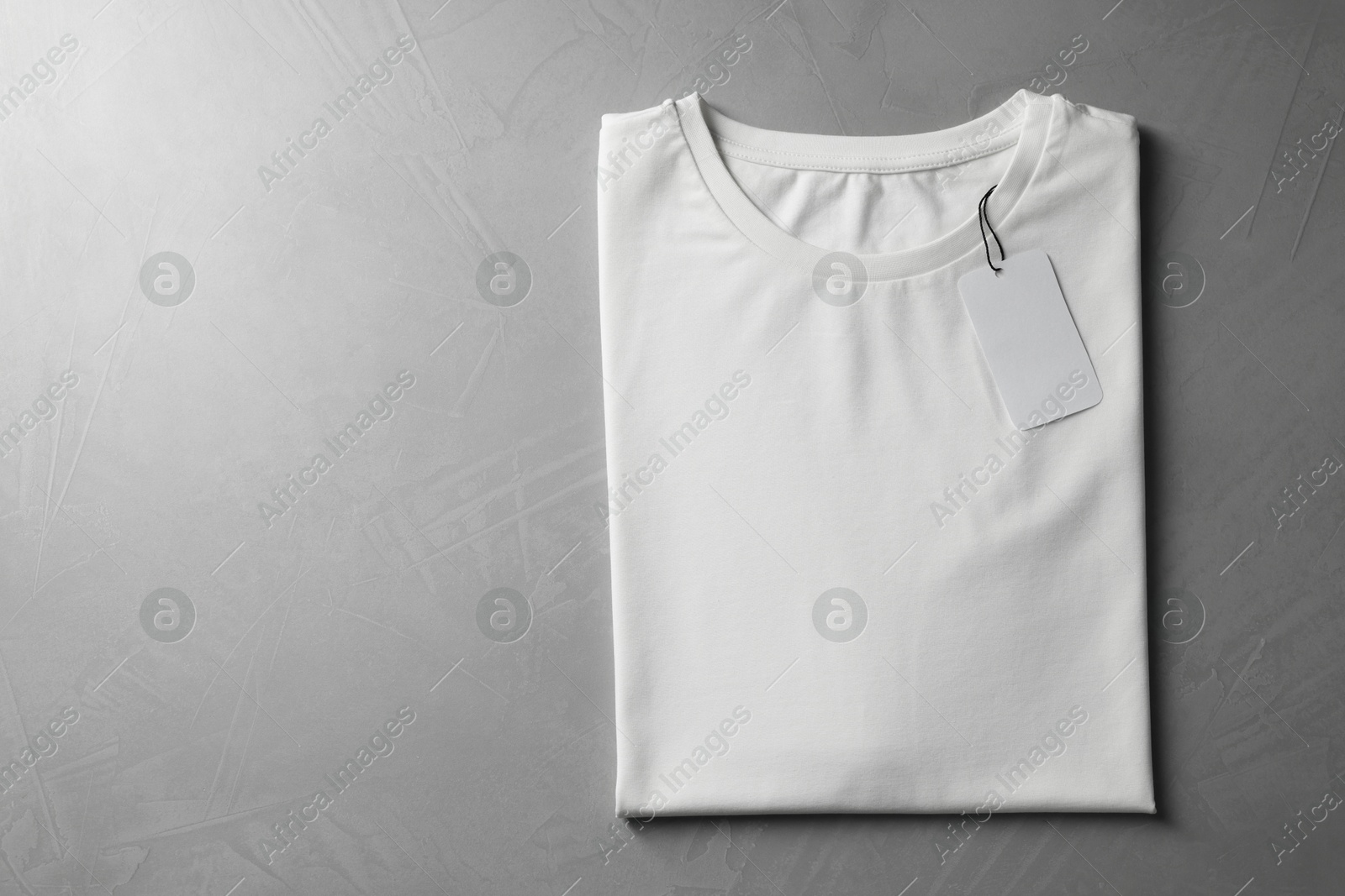 Photo of Blank white t-shirt on grey background, top view. Mockup for design