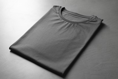 Photo of Blank t-shirt on grey table, closeup. Mockup for design