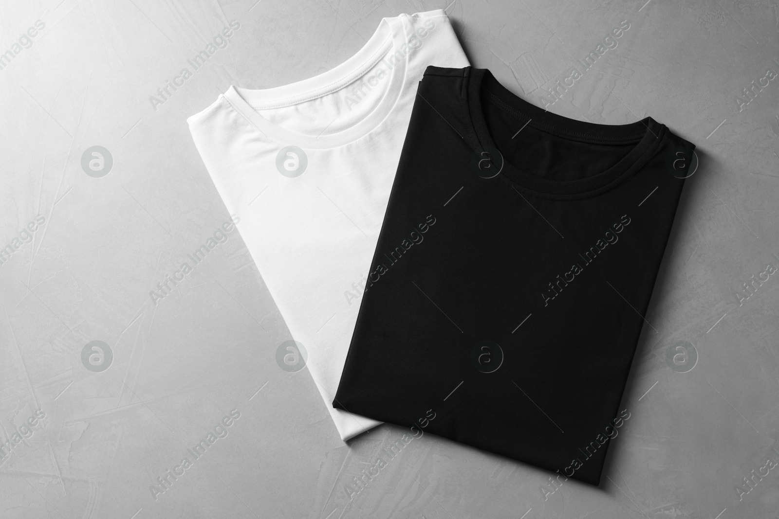 Photo of Different blank t-shirts on grey background, top view. Mockup for design