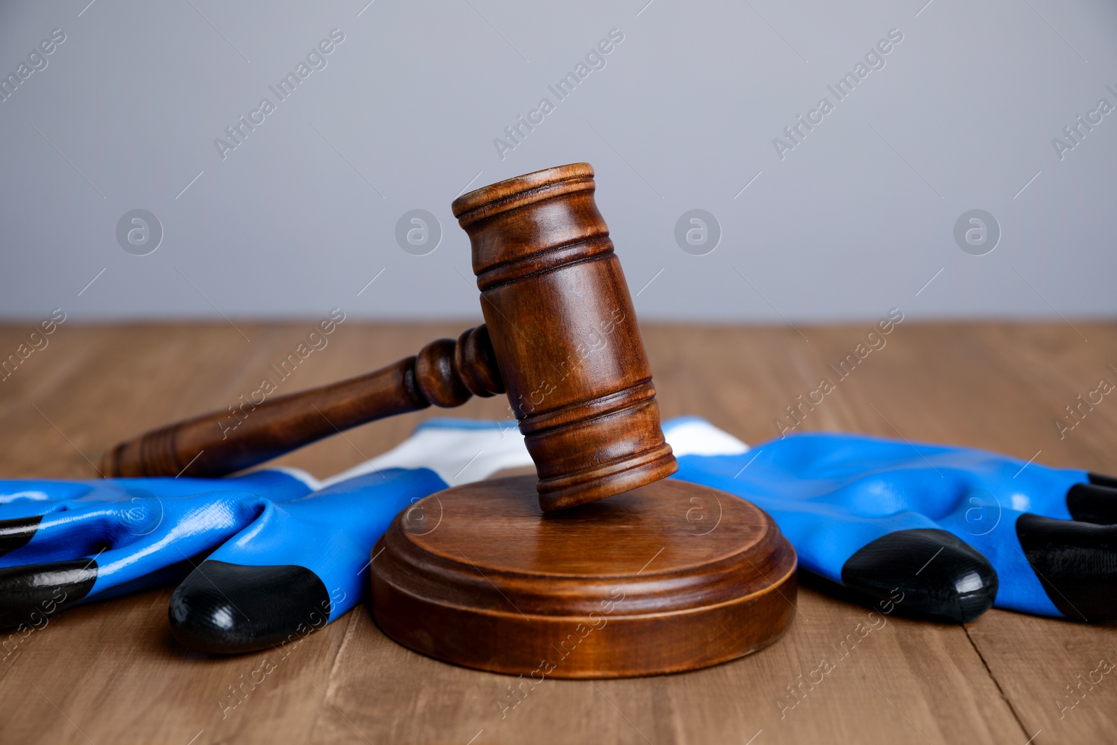 Photo of Accident at work concept. Gavel and construction worker's protective gear on wooden table