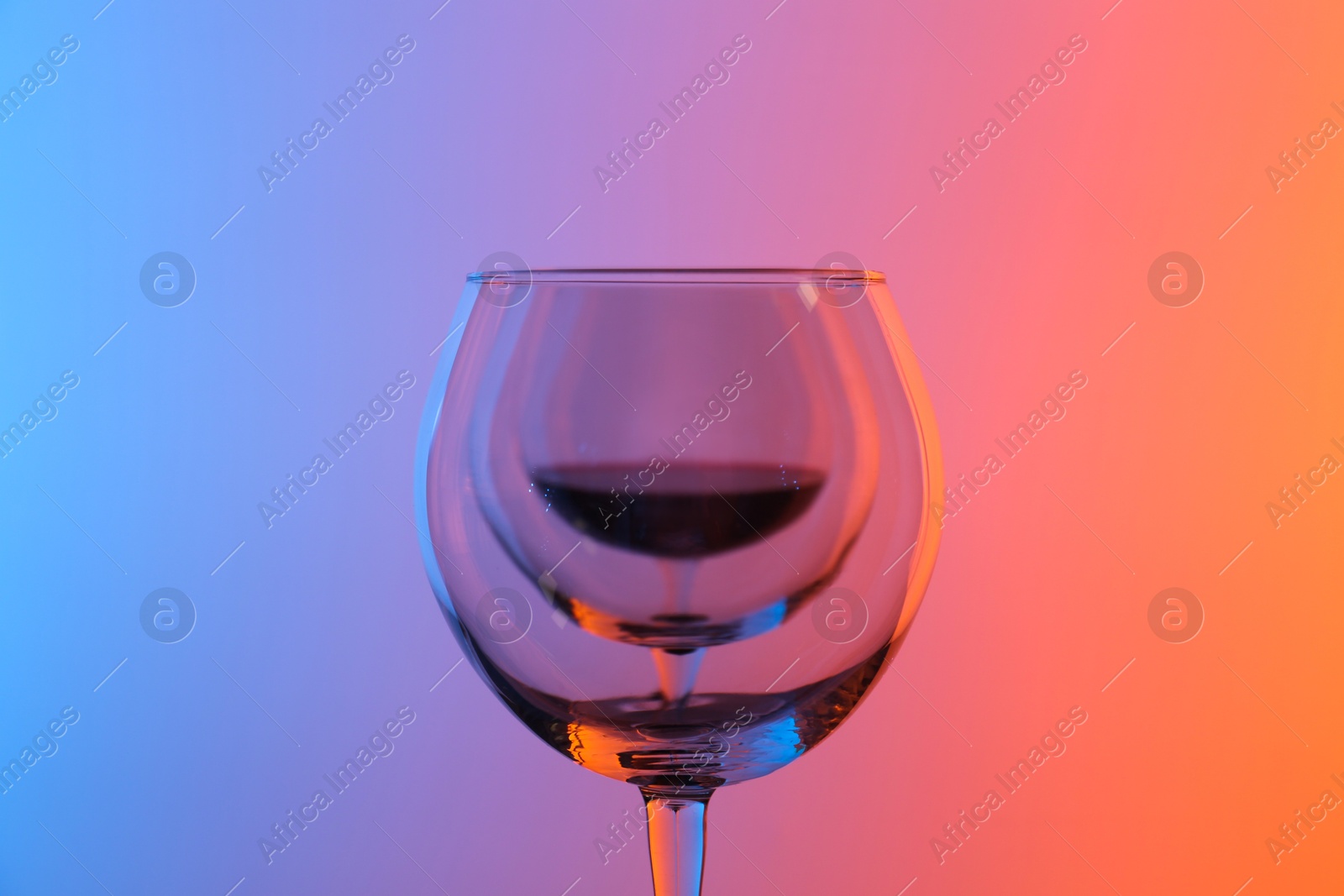 Photo of Wine glasses on color background, closeup view