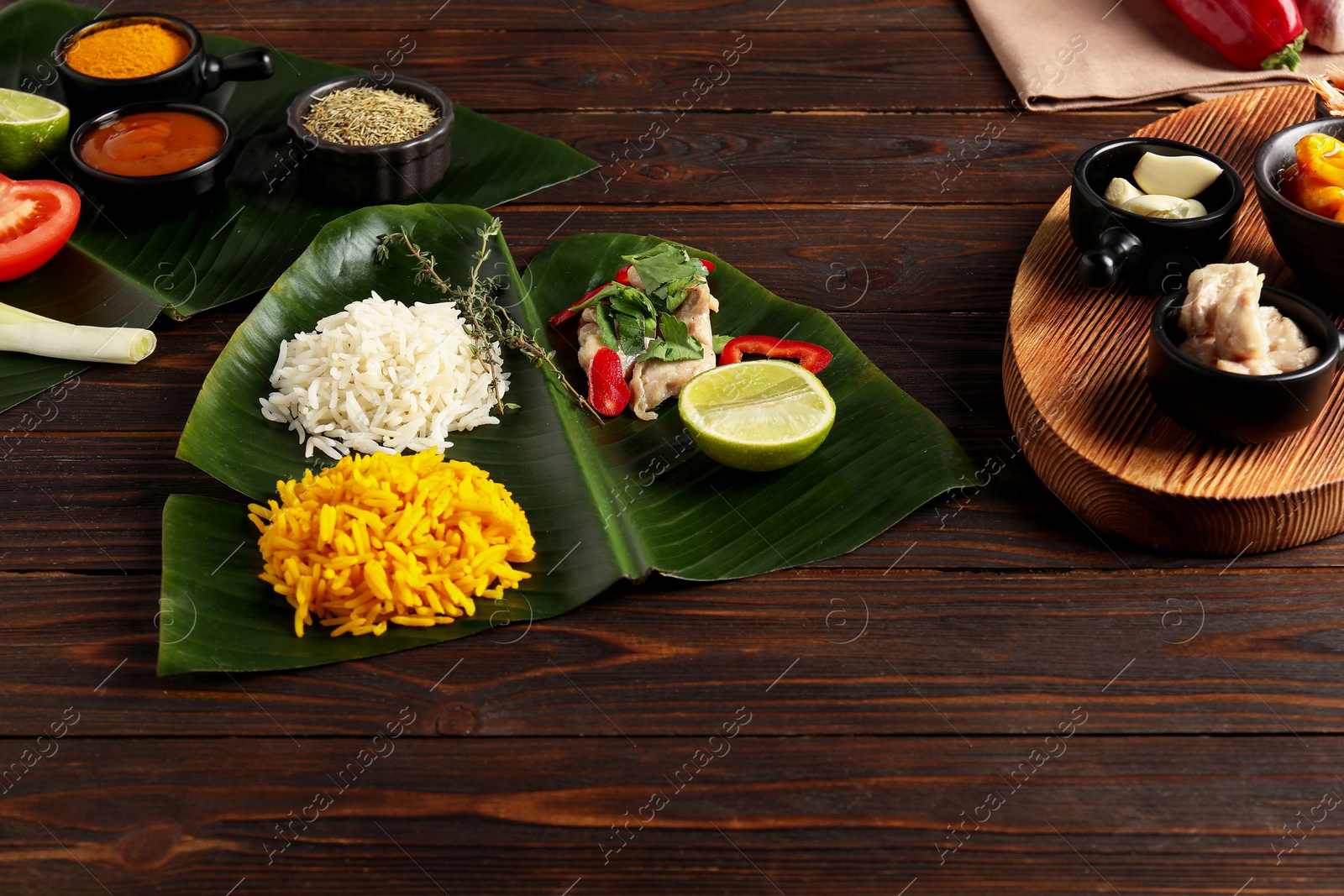 Photo of Cut banana leaf with different food on wooden table