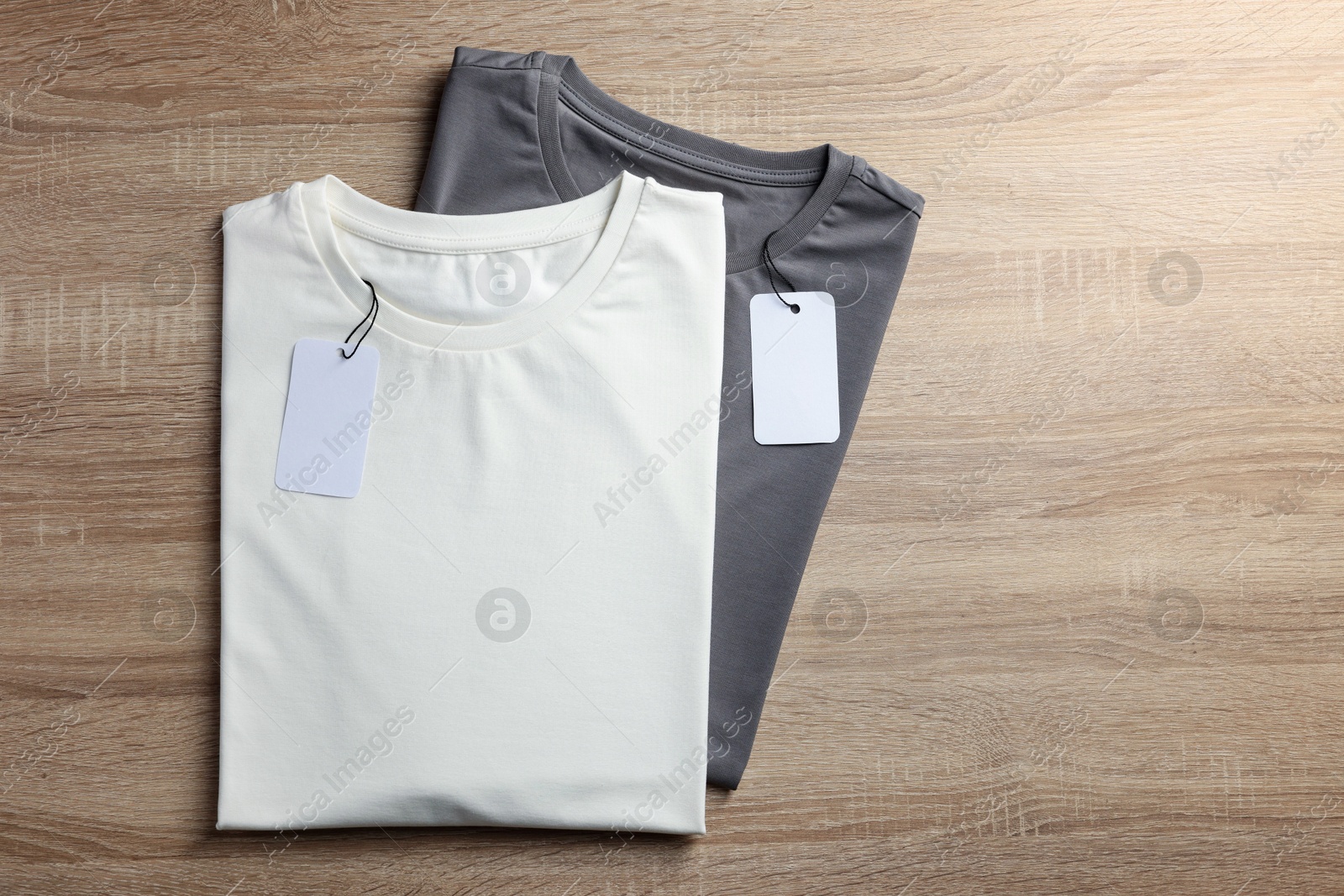 Photo of Blank t-shirts on wooden background, flat lay. Mockup for design