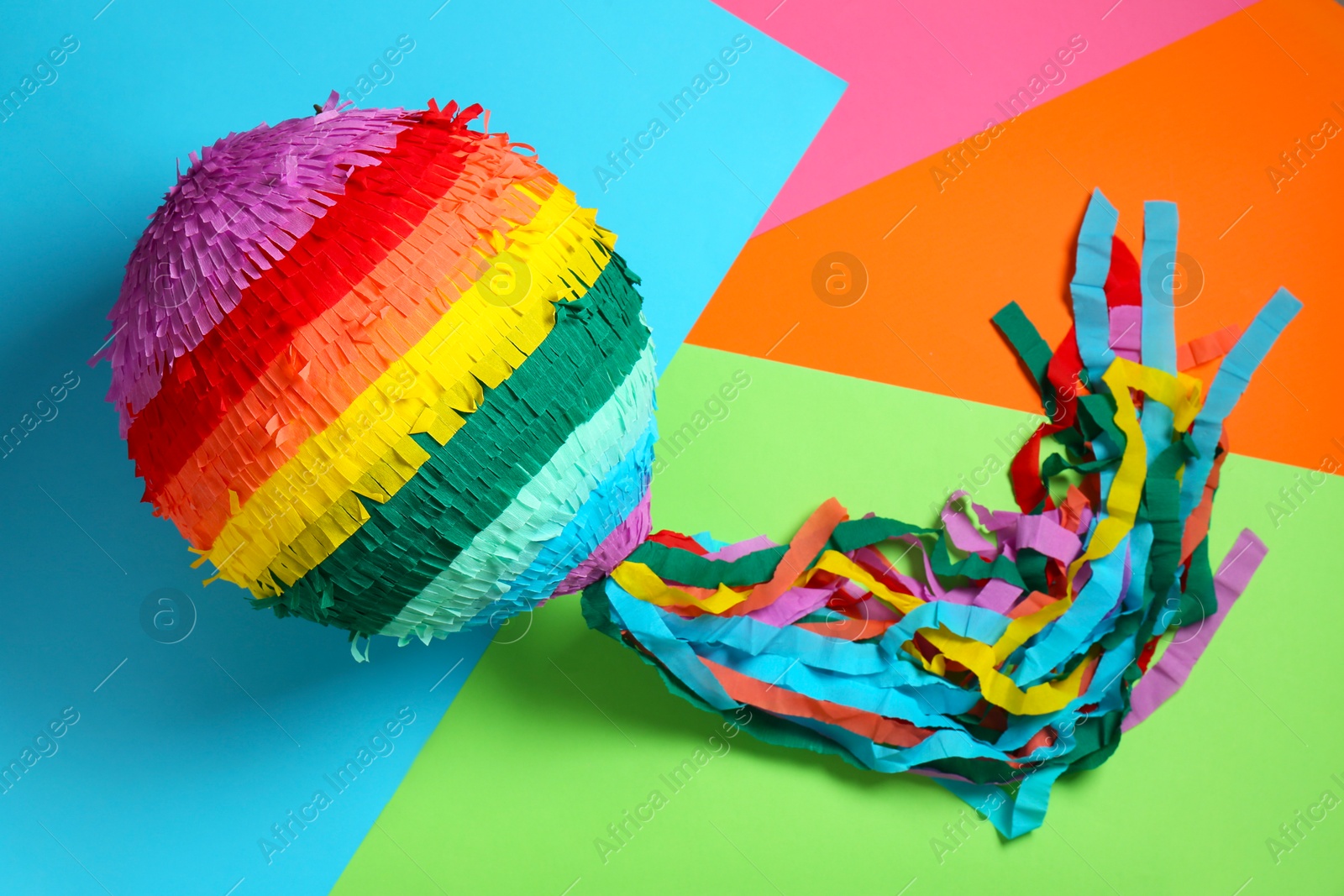 Photo of Colorful pinata on color background, top view