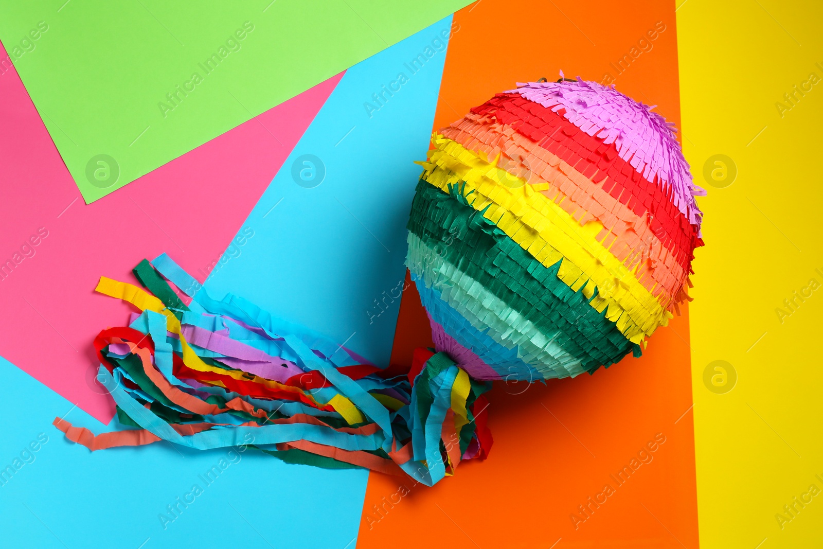 Photo of Colorful pinata on color background, top view