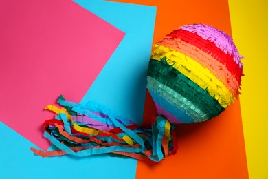 Photo of Colorful pinata on color background, top view