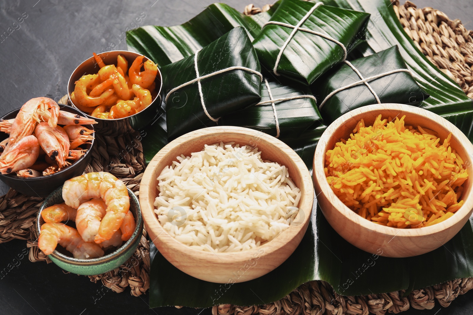 Photo of Cut banana leaves with different food on dark table, closeup. Healthy eco serving