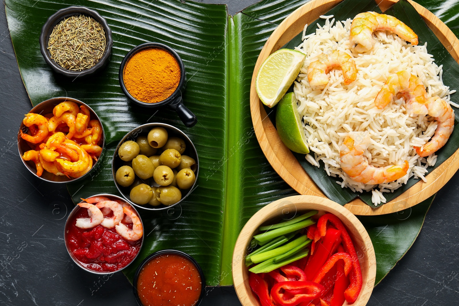 Photo of Piece of banana leaf with different food, spices and sauce on grey textured table, top view. Healthy eco serving