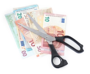 Photo of Euro banknotes and scissors isolated on white, top view