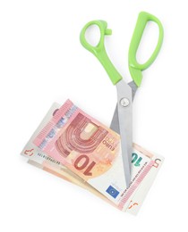 Photo of Euro banknotes and scissors isolated on white, top view