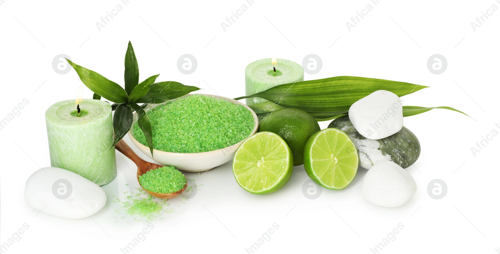 Spa composition with fresh limes, sea salt, massage stones and bamboo leaves isolated on white Photo of Spa composition with fresh limes, sea salt, massage stones and bamboo leaves isolated on white