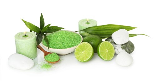 Photo of Spa composition with fresh limes, sea salt, massage stones and bamboo leaves isolated on white