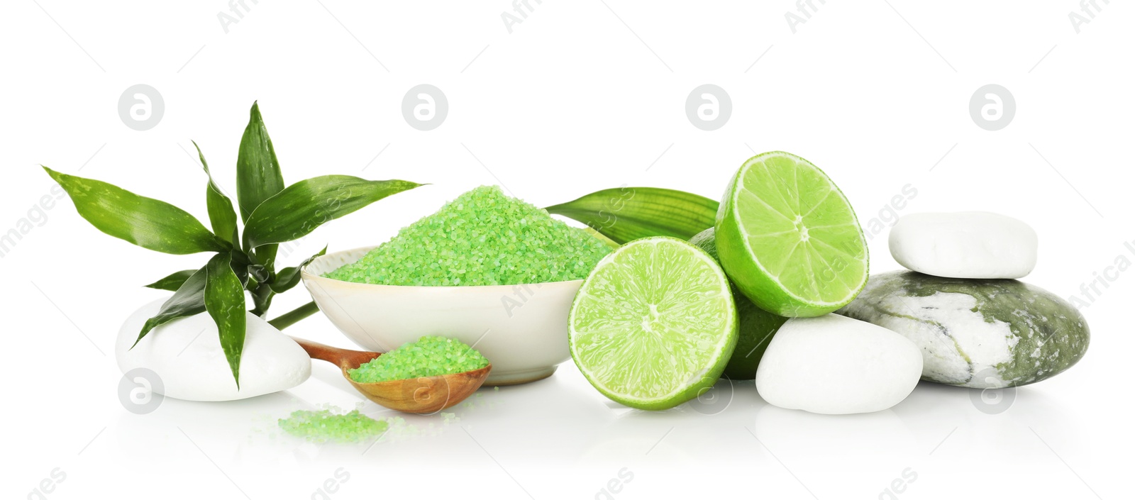 Spa composition with fresh limes, sea salt, massage stones and bamboo leaves on mirror surface against white background Photo of Spa composition with fresh limes, sea salt, massage stones and bamboo leaves on mirror surface against white background