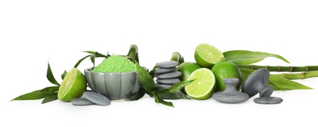 Photo of Spa composition with fresh limes, sea salt, massage stones and bamboo isolated on white