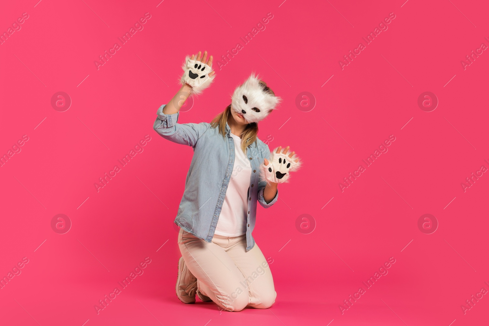 Photo of Quadrobics. Woman wearing cat mask and gloves on pink background