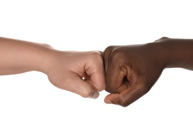 Photo of Stop racism. People of different skin colors bumping fists on white background, closeup