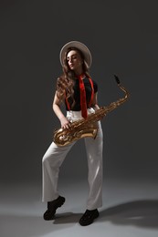 Photo of Professional musician with saxophone on grey background