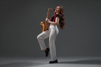 Photo of Professional musician playing saxophone on grey background