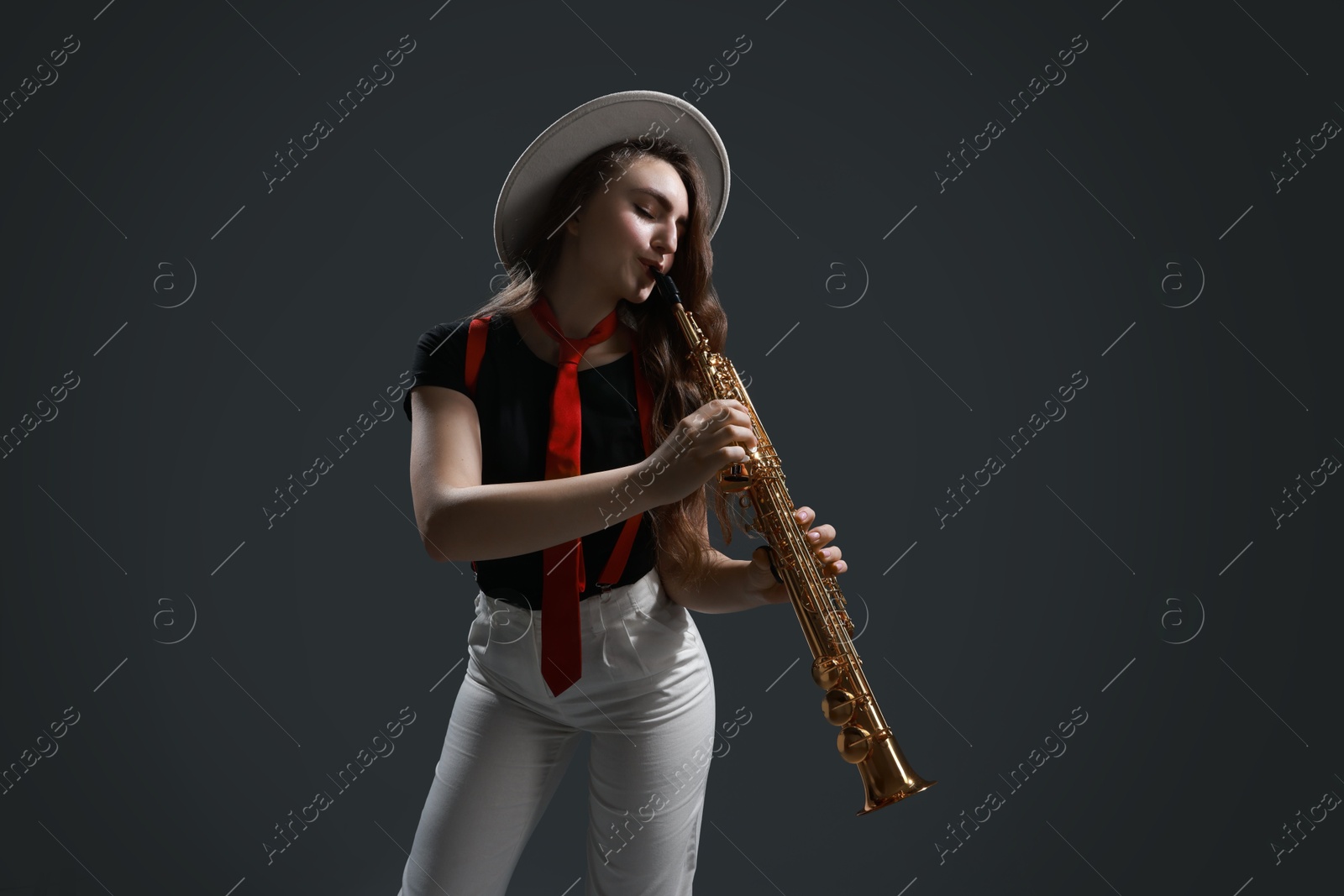 Photo of Musician playing soprano saxophone on grey background