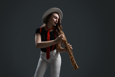 Photo of Musician playing soprano saxophone on grey background