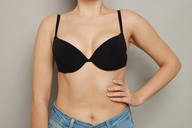 Photo of Woman wearing beautiful bra on light background, closeup