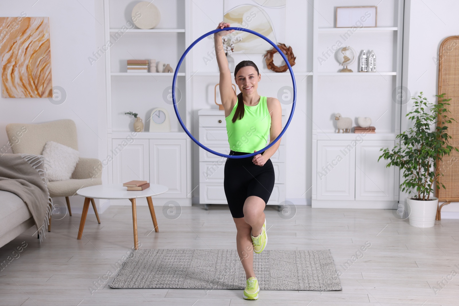 Photo of Smiling woman with hula hoop at home