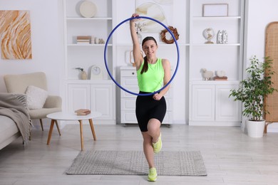 Photo of Smiling woman with hula hoop at home