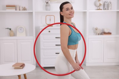 Photo of Smiling woman with hula hoop at home