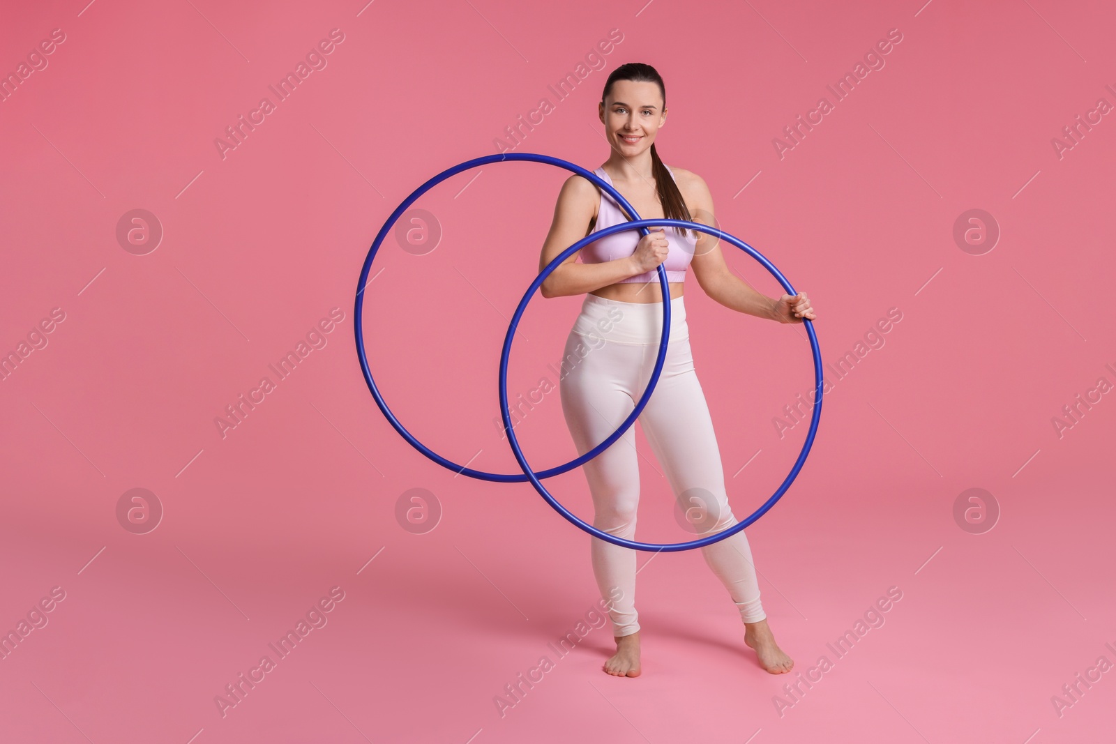 Photo of Smiling woman with hula hoops on pink background