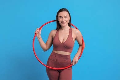 Photo of Smiling woman with hula hoop on light blue background