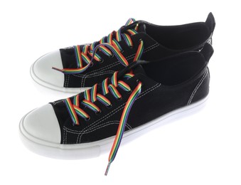 Photo of Black shoes with bright rainbow laces on white background. LGBT concept