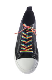 Photo of Black shoe with bright rainbow lace on white background, above view. LGBT concept