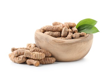 Photo of Raw turmeric roots and green leaves isolated on white