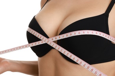 Photo of Woman in beautiful bra measuring breast circumference on white background, closeup