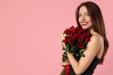 Photo of Happy Valentine's Day. Beautiful woman with bouquet of roses on pink background. Space for text