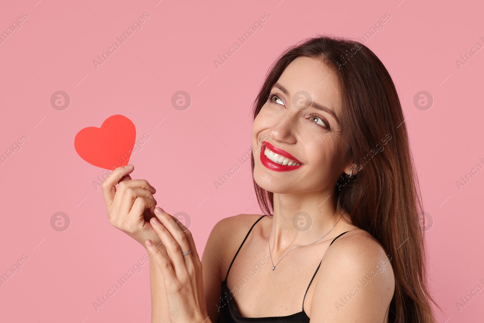 Photo of Happy Valentine's Day. Beautiful woman with paper heart on pink background