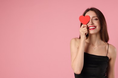 Photo of Happy Valentine's Day. Beautiful woman with paper heart on pink background. Space for text