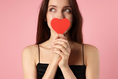 Photo of Happy Valentine's Day. Beautiful woman with paper heart on pink background