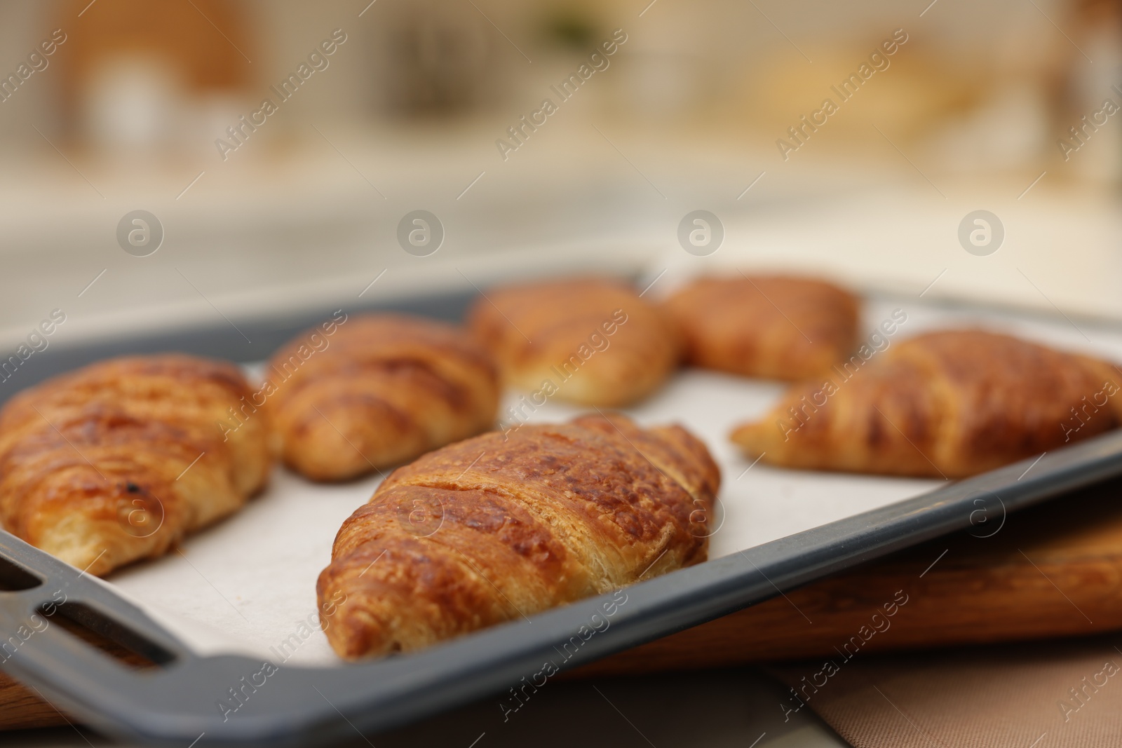 Photo of Freshly baked croissants on table indoors, closeup