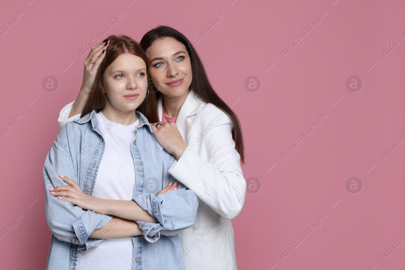 Photo of Portrait of beautiful mother with teenage daughter on pink background, space for text